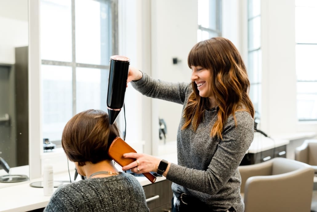 A woman hair stylist chats with a client.