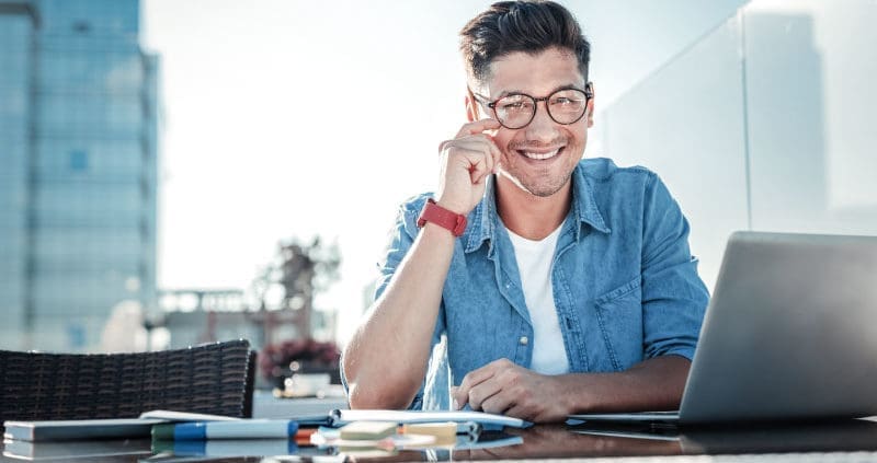 a man sitting in front of a laptop