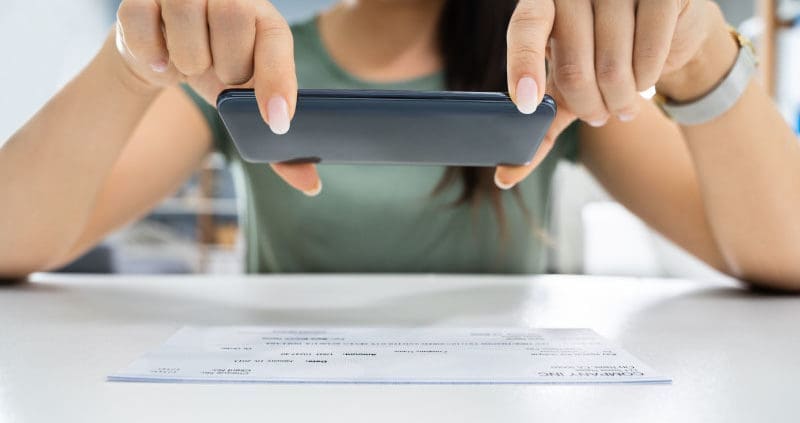 a person taking an image of a bill