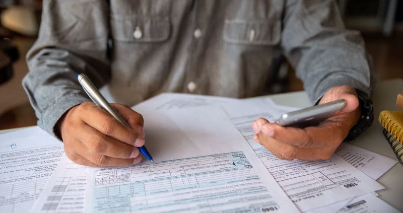 a person writing on 1040 forms