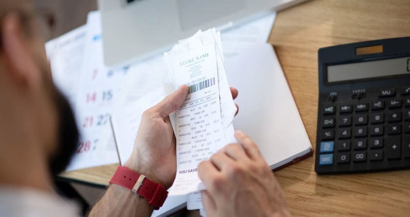 a business owner looking at paper receipts