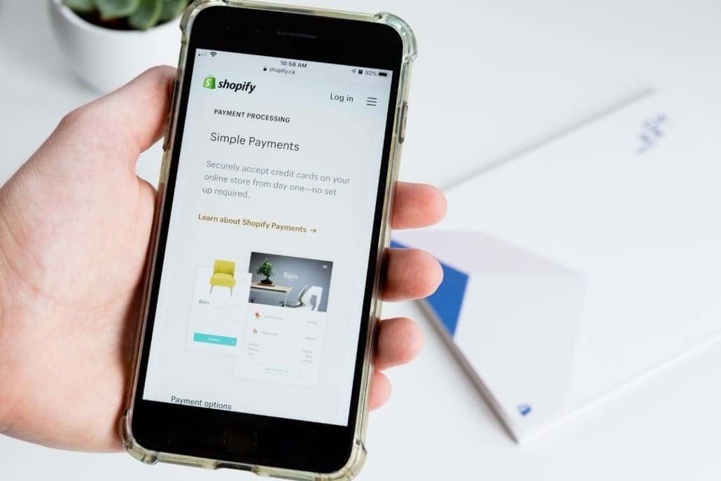 A person holds their phone lookig at a recent Shopify order