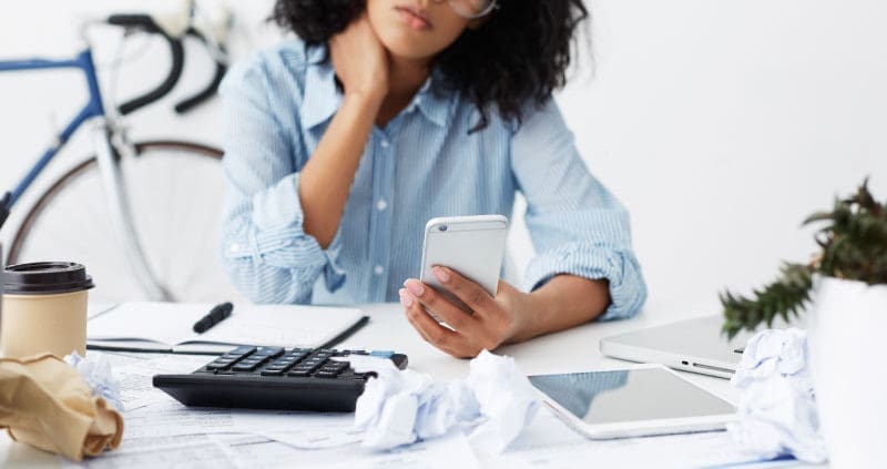 a self-employed person looking at a phone and doing taxes