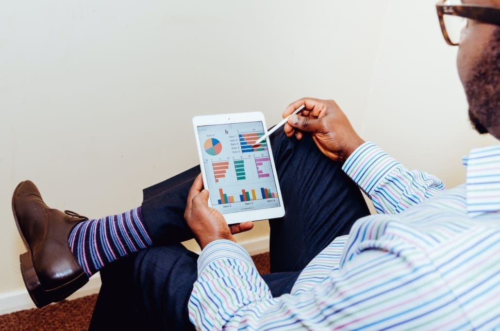 A real estate agent looks over his accounting charts on a tablet.