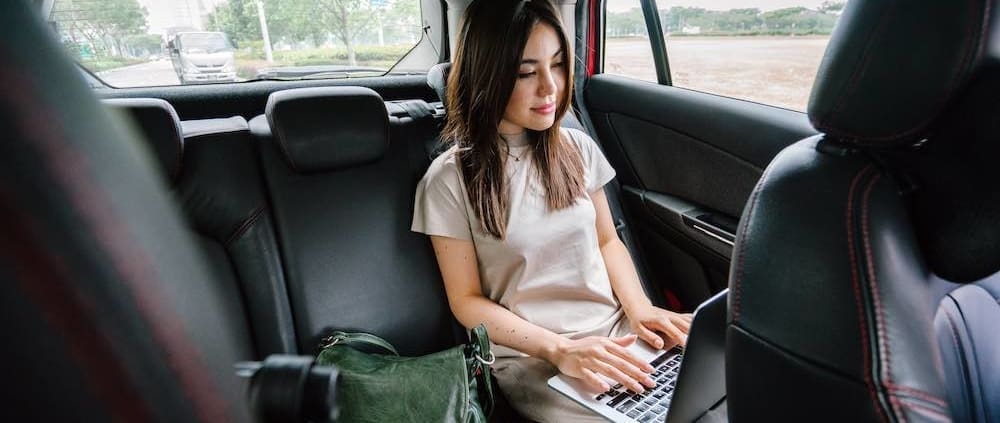 A woman working while riding in a rideshare