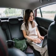 A woman working while riding in a rideshare