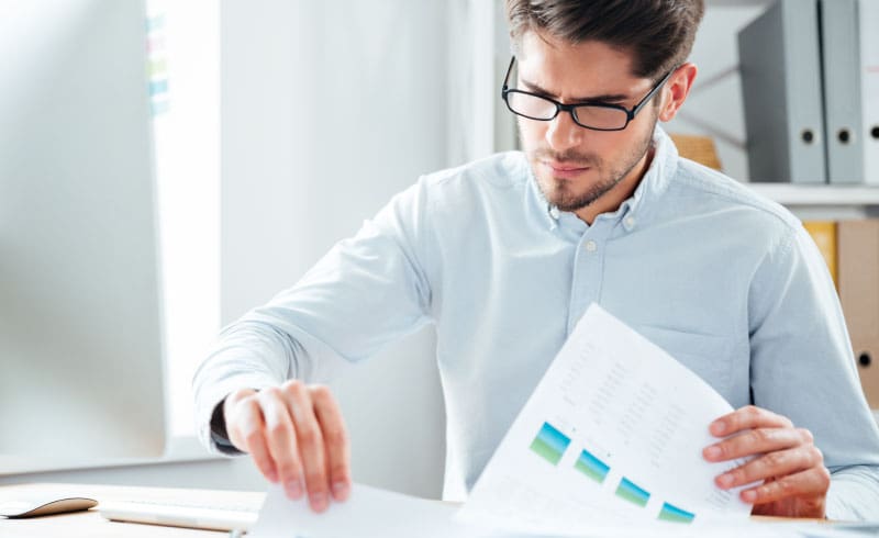 a man looking at accounting documents