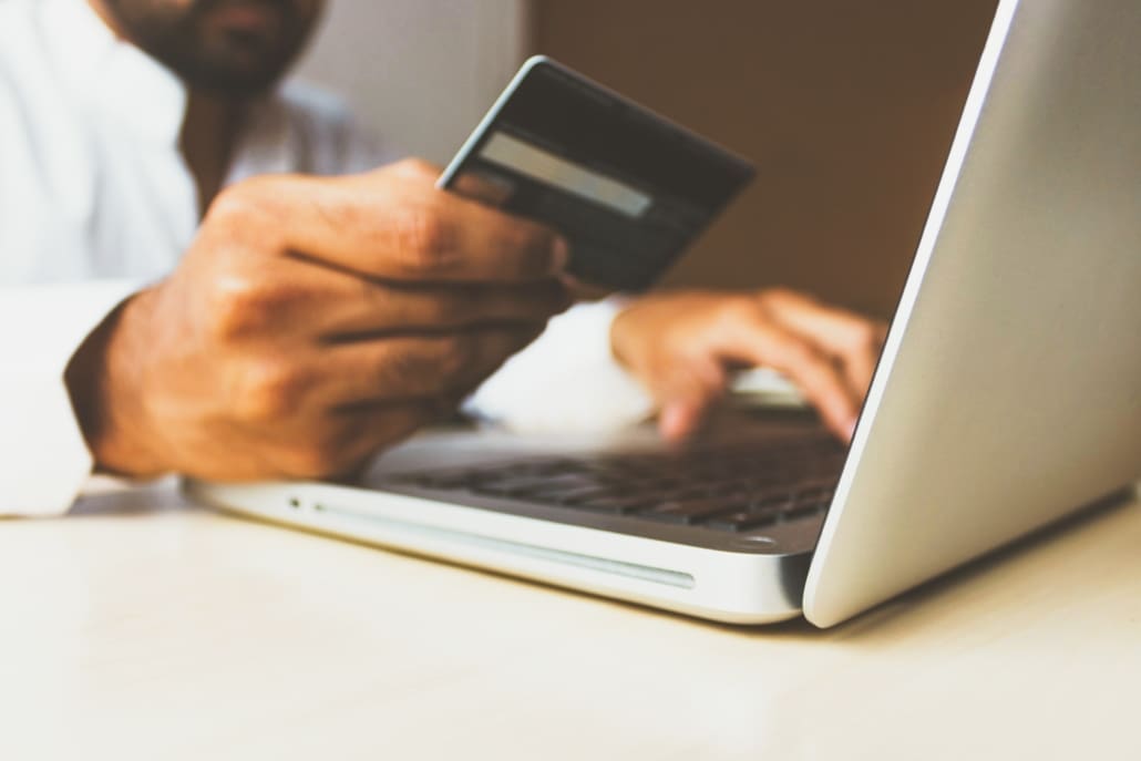 A business man uses a credit card to buy something online