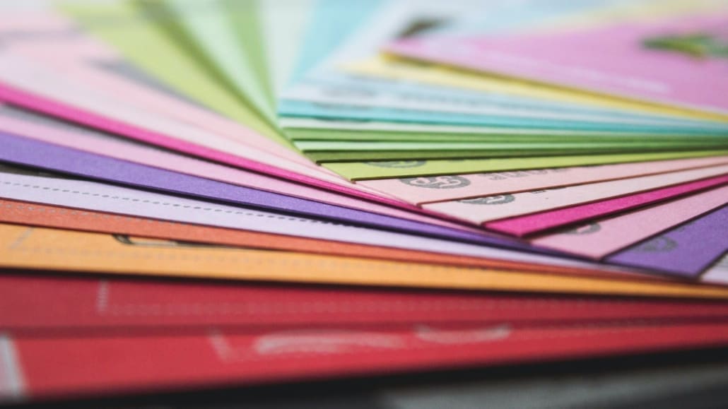 Finacial documents in a assorted colored folder fan across a table.