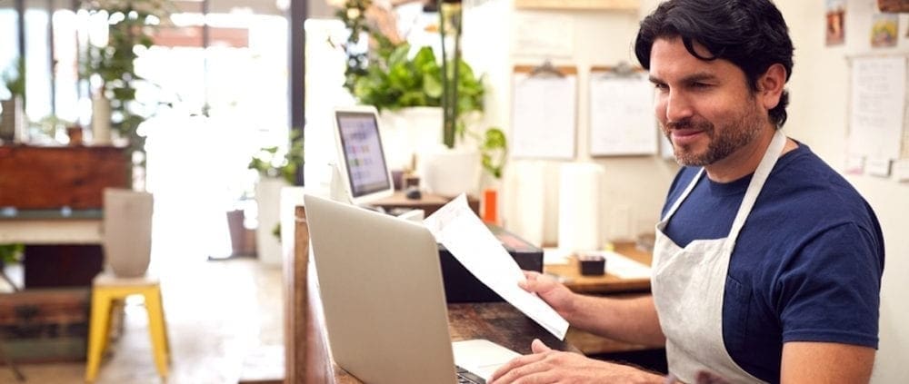 A store owner inputting payroll data into a computer