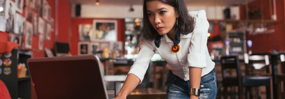 Asian female business owner, working on her laptop in her art studio