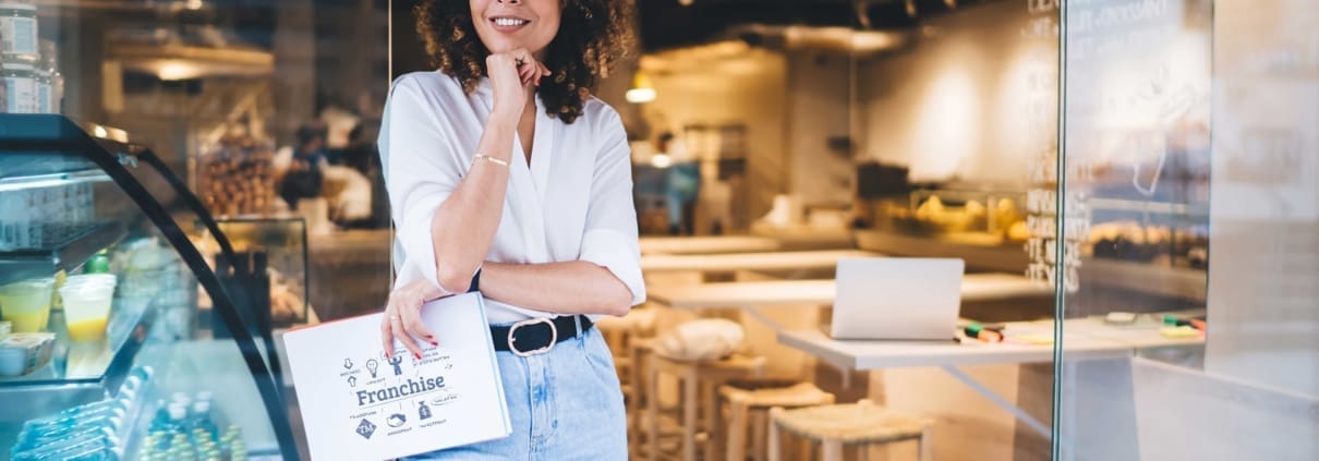 A black female franchise owner, holding her Item 19 report, thinking about the future of her business