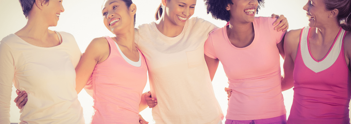 A group of breast cancer survivors hugging and smiling at each other