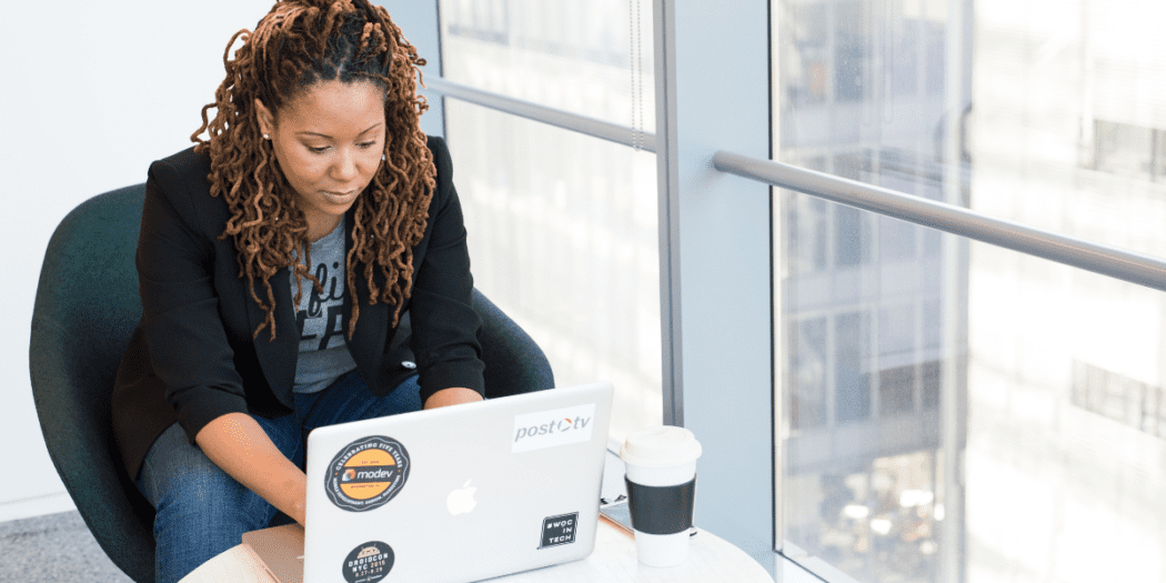 A young black woman works on a laptop to prepare her small business for the new year