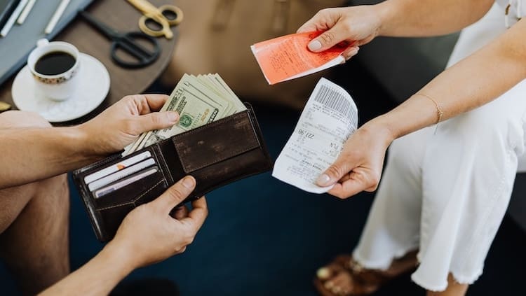 Two people exchanging receipts and money