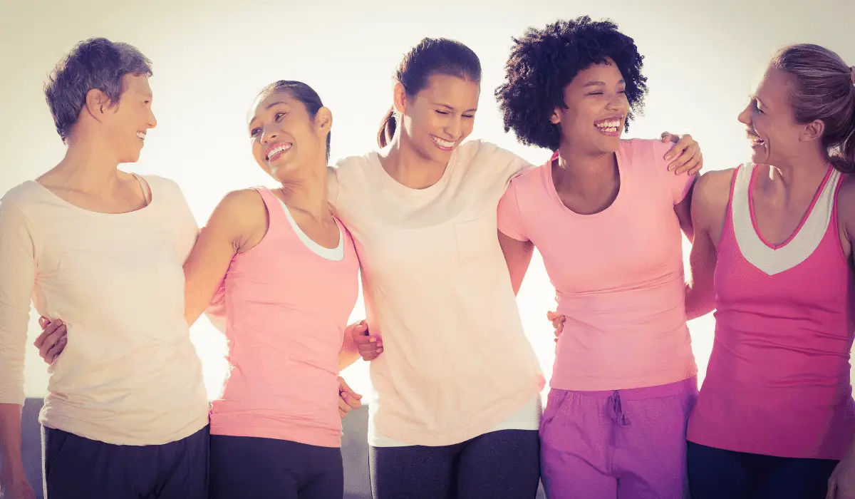 A group of breast cancer survivors hugging and smiling at each other