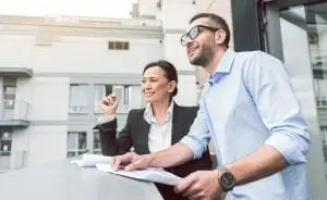 real estate accountants|Two men go over real esate regulations at their desk.|A broker goes over his taxes for his real estate business.