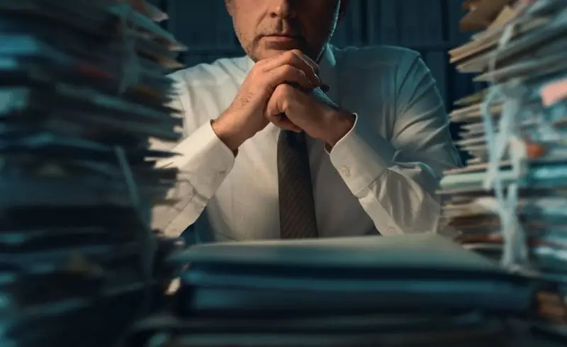 a person sitting in front of stacks of paper