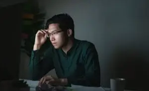 a person looking at a computer in a dark room