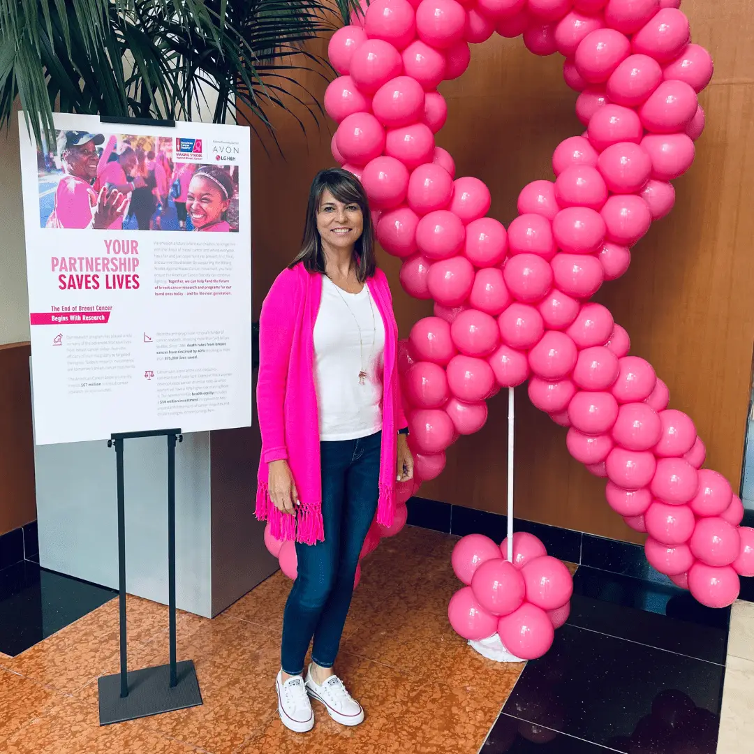 Julia Aquino, xendoo COO, poses with the Breast Cancer Awareness Month pink ribbon.