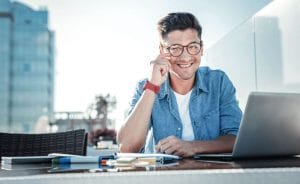 a man sitting in front of a laptop