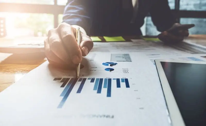 a person writing on financial reports