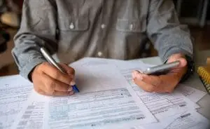 a person writing on 1040 forms