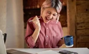 a woman celebrating with a cup of coffee