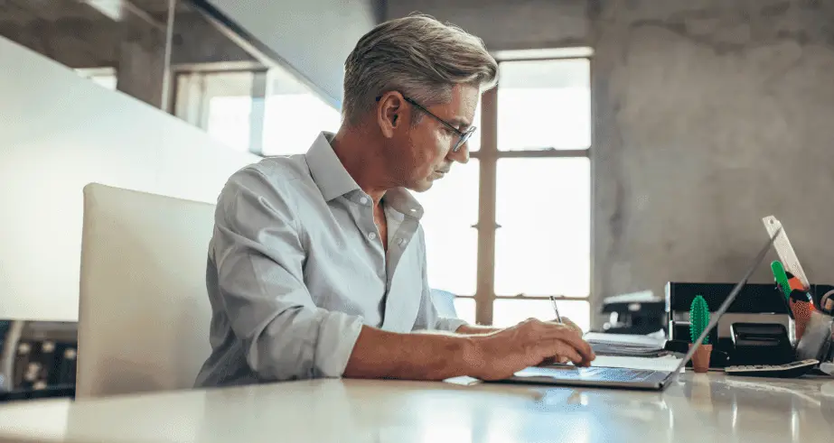 businessman working at his desk boosting profitability