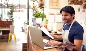 A store owner inputting payroll data into a computer