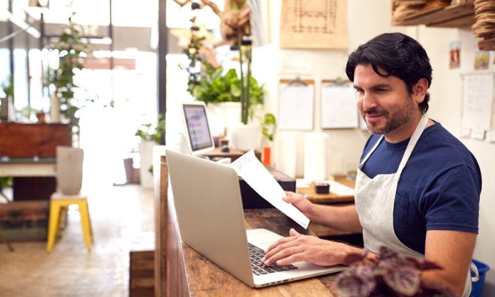 A store owner inputting payroll data into a computer