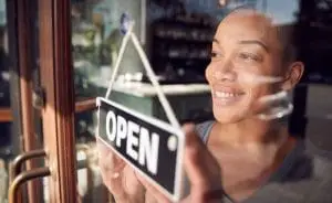a store owner putting up an open sign