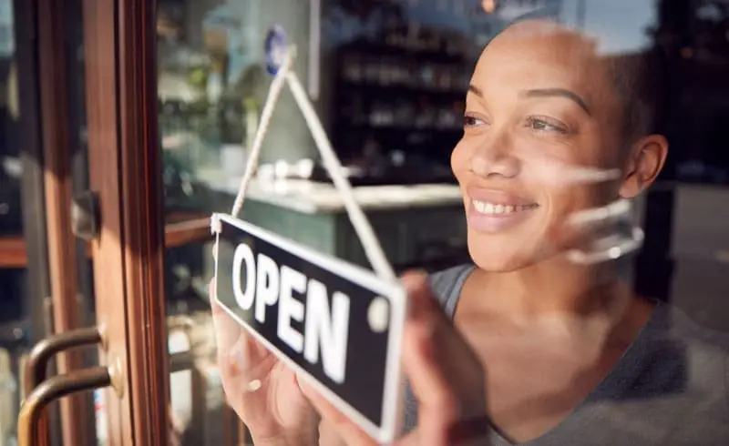 a store owner putting up an open sign