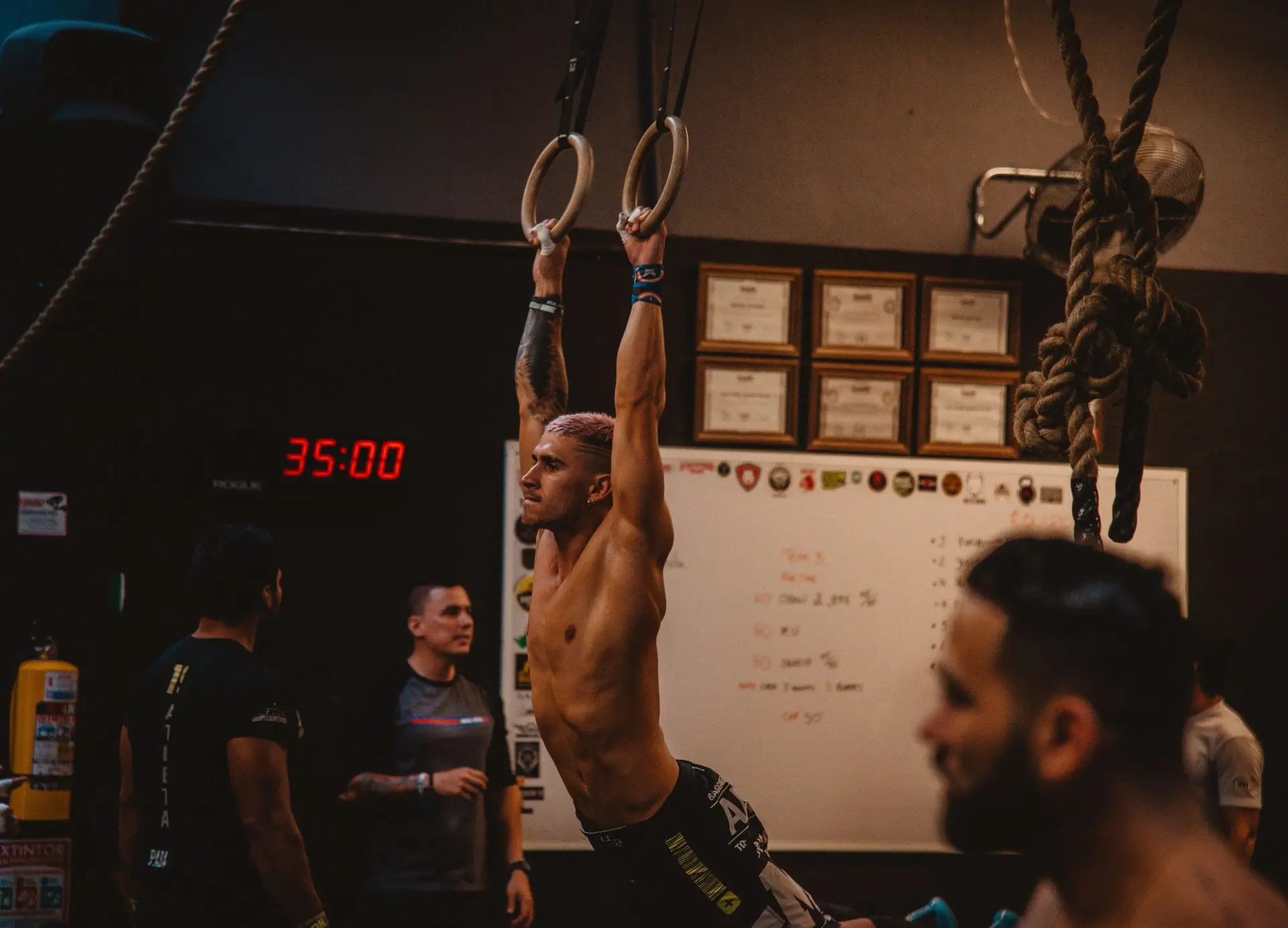 A man holding onto rings tries to beat a record for a gym contest