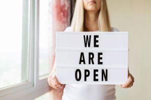 person with an open sign