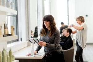 A salon owner checks her profit marginson a tablet